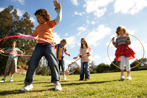 kid jumping through hula hoop; fun large group games for kids